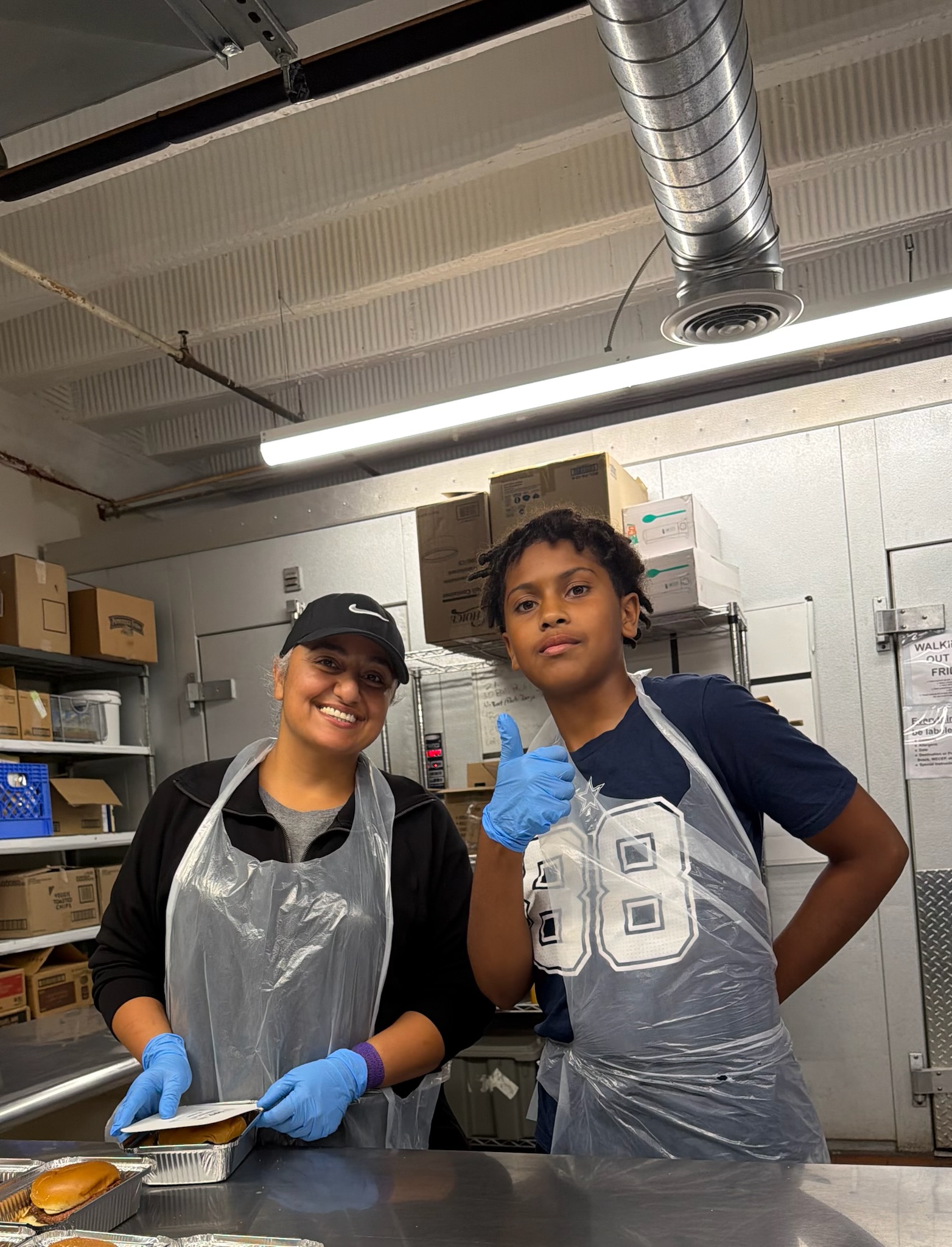 Two volunteers in aprons in the RMHL kitchen