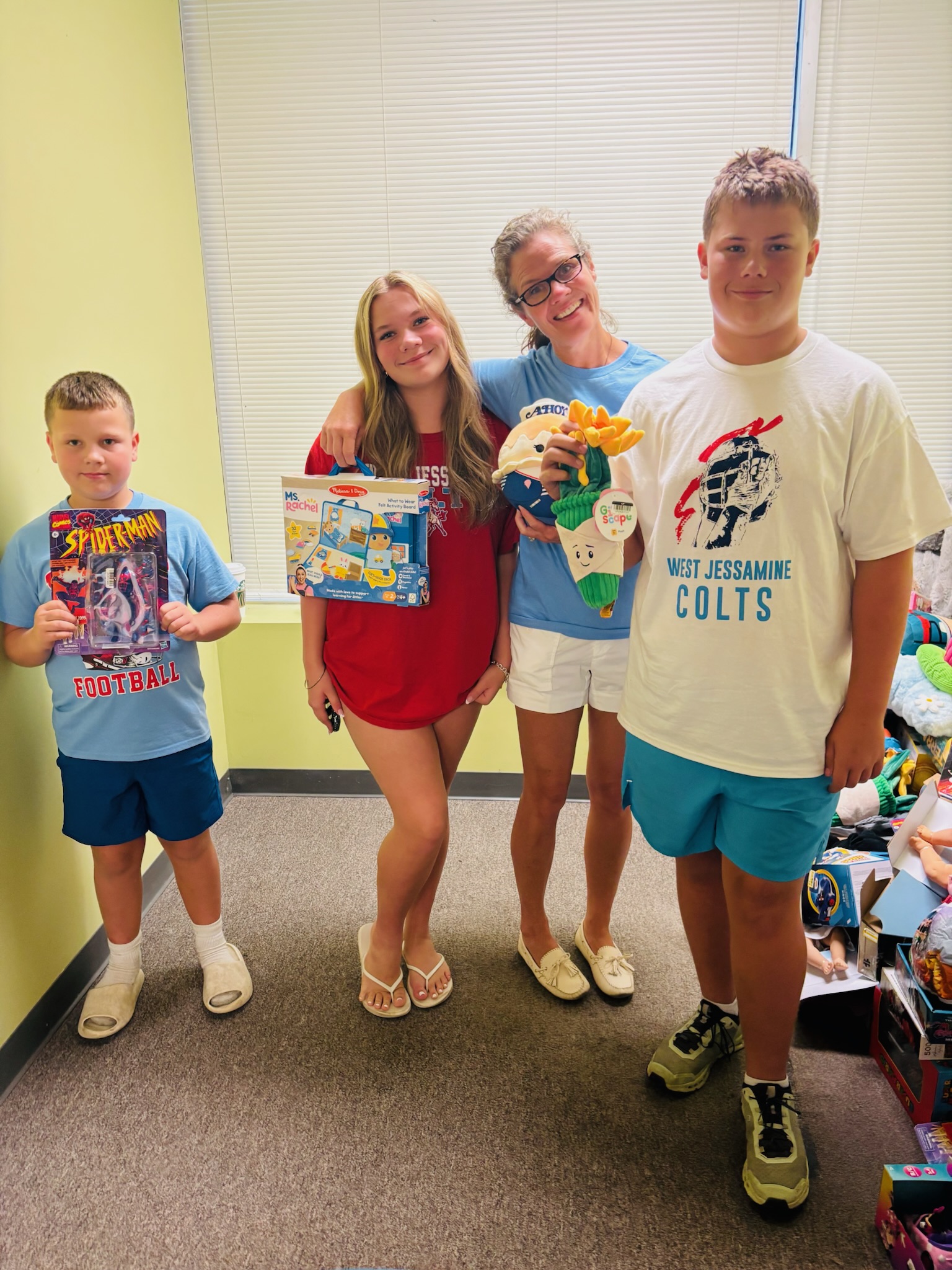 Kids holding up donated toys at Operation Secret Santa