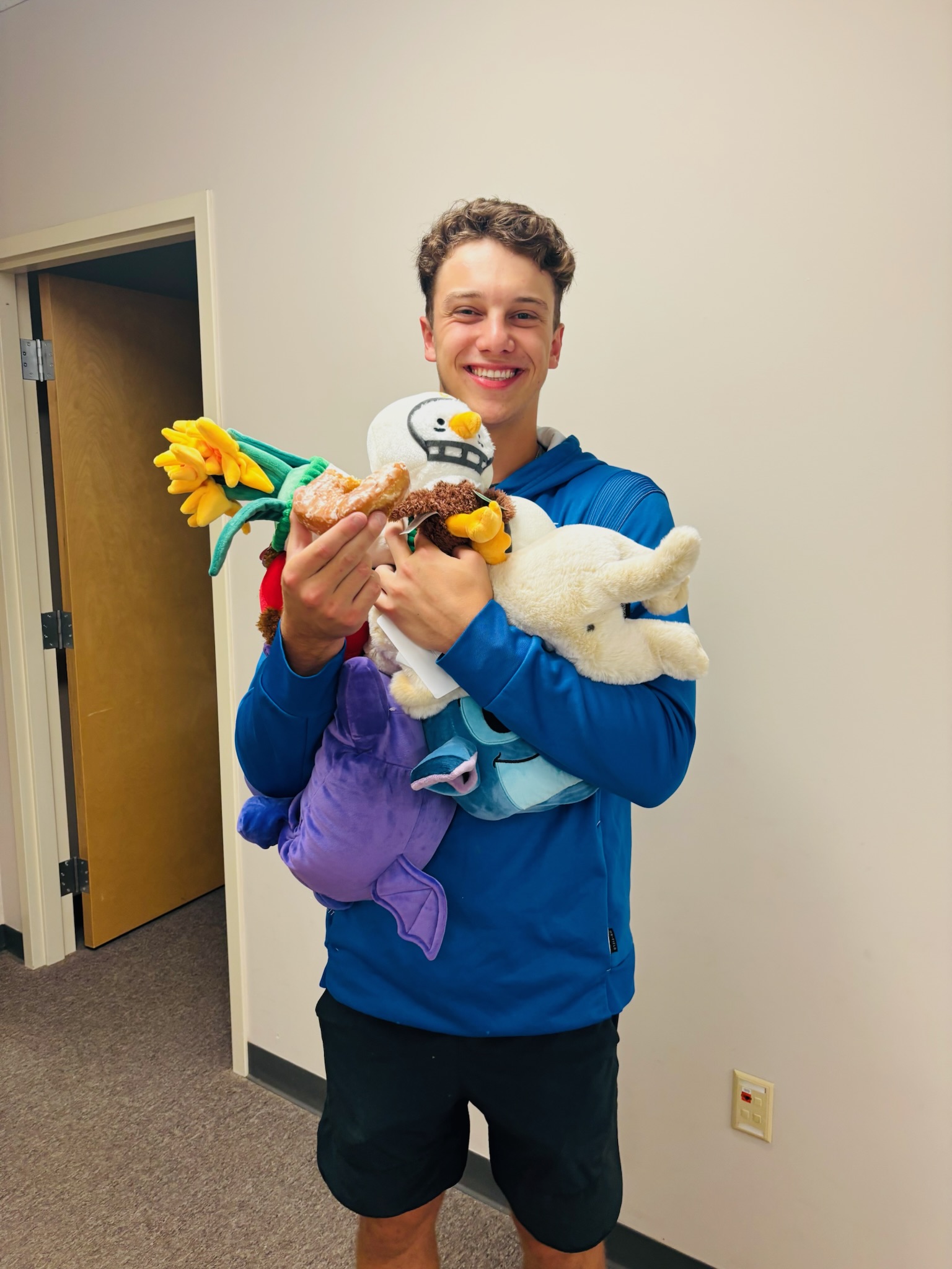 Volunteer holding an armful of stuffed animals