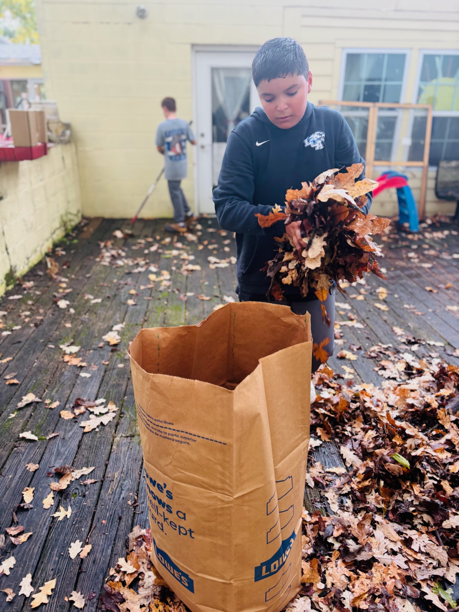 Volunteer filling a paper leaf bag