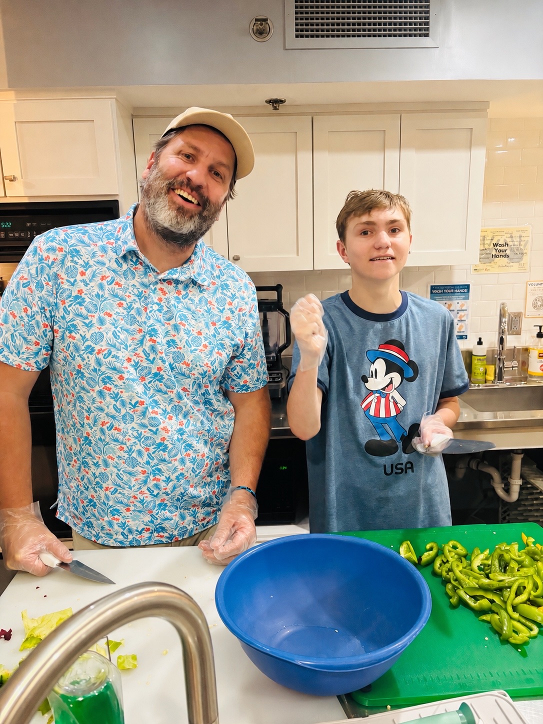 Father and son prepping vegetables in the RMHL kitchen